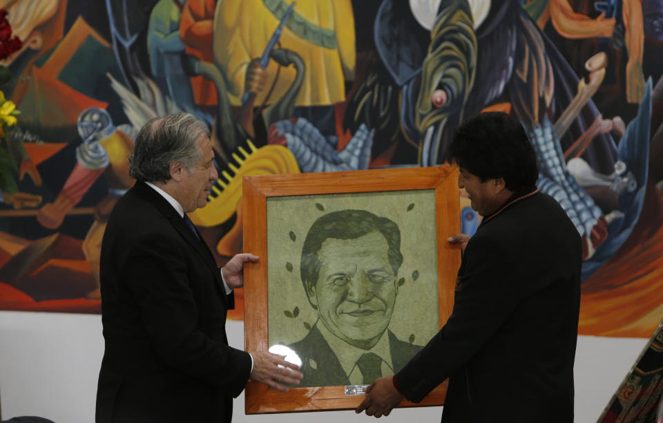 El secretario general de la Organización de Estados Americanos, Luis Almagro, a la izquierda, recibe un retrato de sí mismo diseñado con hojas de coca pintadas del presidente de Bolivia, Evo Morales, en el palacio de gobierno de La Paz, Bolivia, el viernes 17 de mayo de 2019. (AP Foto / Juan Karita)