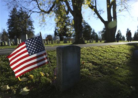 People walk past the headstone of Union Captain William Miller, a Medal of Honor winner, at the Gettysburg National Cemetery in Pennsylvania November 18, 2013. REUTERS/Gary Cameron