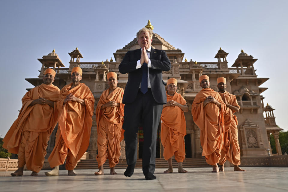 FILE - Britain's Prime Minister Boris Johnson, center, poses with Sadhus, or Hindu holy men, in front of the Swaminarayan Akshardham temple, in Gandhinagar, part of his two-day trip to India, Thursday, April 21, 2022. British media say Prime Minister Boris Johnson has agreed to resign on Thursday, July 7 2022, ending an unprecedented political crisis over his future. (Ben Stansall/Pool Photo via AP)