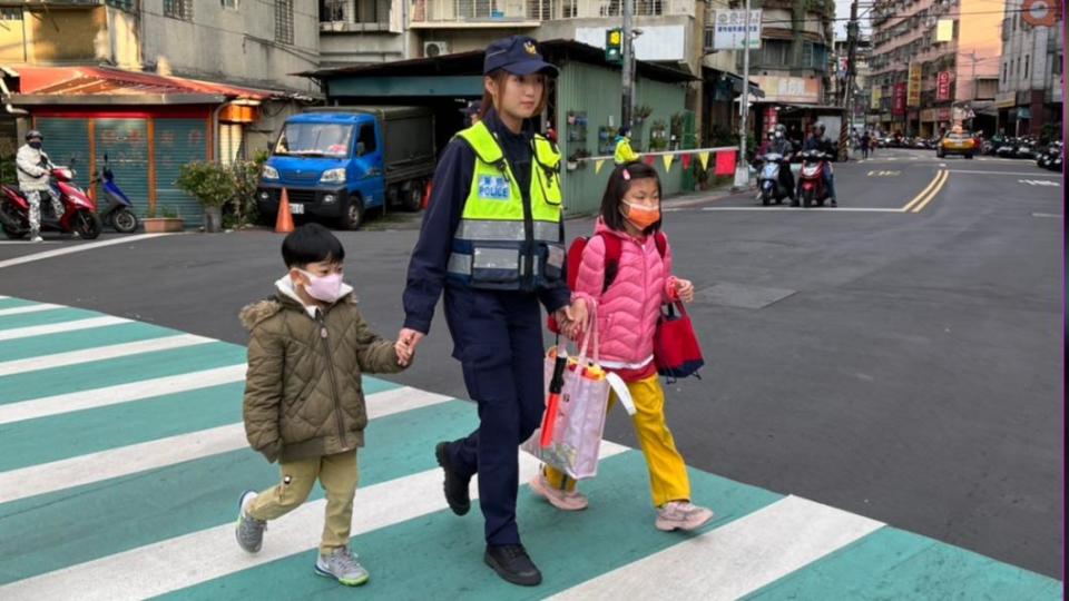 中和分局女警貼心地牽著學童們過馬路。（圖／TVBS）