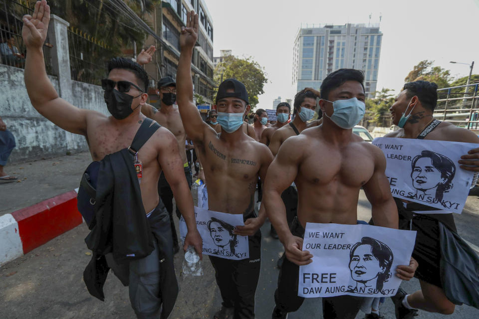 Demonstrator holding images of ousted Myanmar leader Aung San Suu Kyi flash three-fingered salutes, a symbol of resistance, during a protest in Yangon, Myanmar Wednesday, Feb. 10, 2021. Protesters continued to gather Wednesday morning in Yangon breaching Myanmar's new military rulers' decrees that effectively banned peaceful public protests in the country's two biggest cities. (AP Photo)