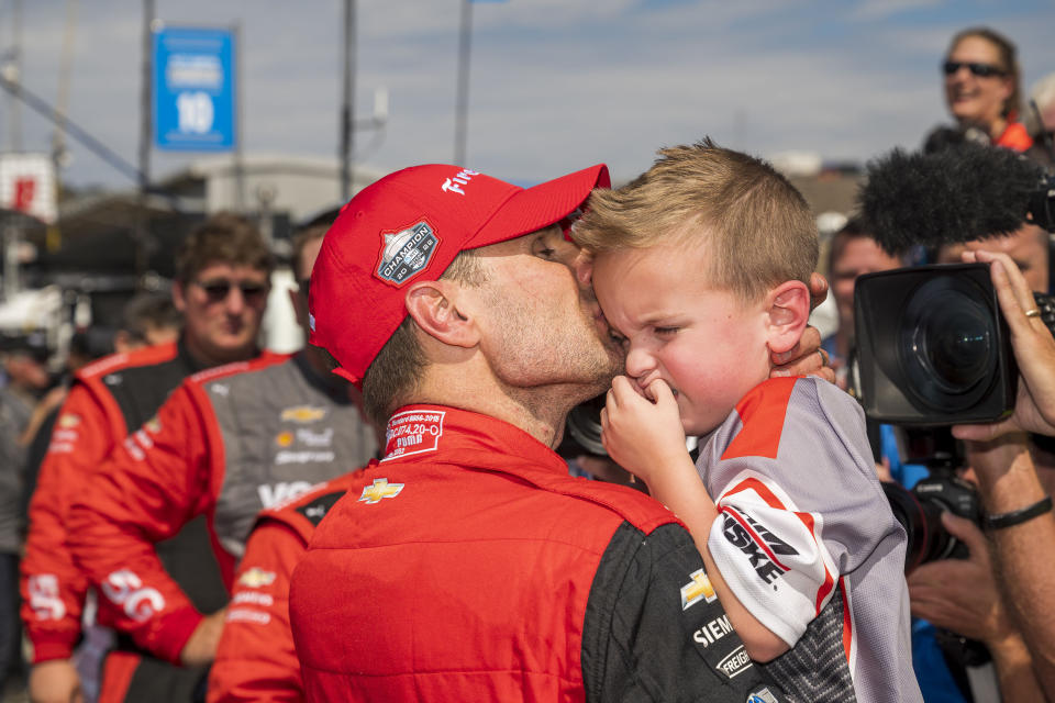 Team Penske driver Will Power, of Australia kisses, his son after winning the championship after the IndyCar season finale auto race at Laguna Seca Raceway on Sunday, Sept. 11, 2022, Monterey, Calif. (AP Photo/Nic Coury)