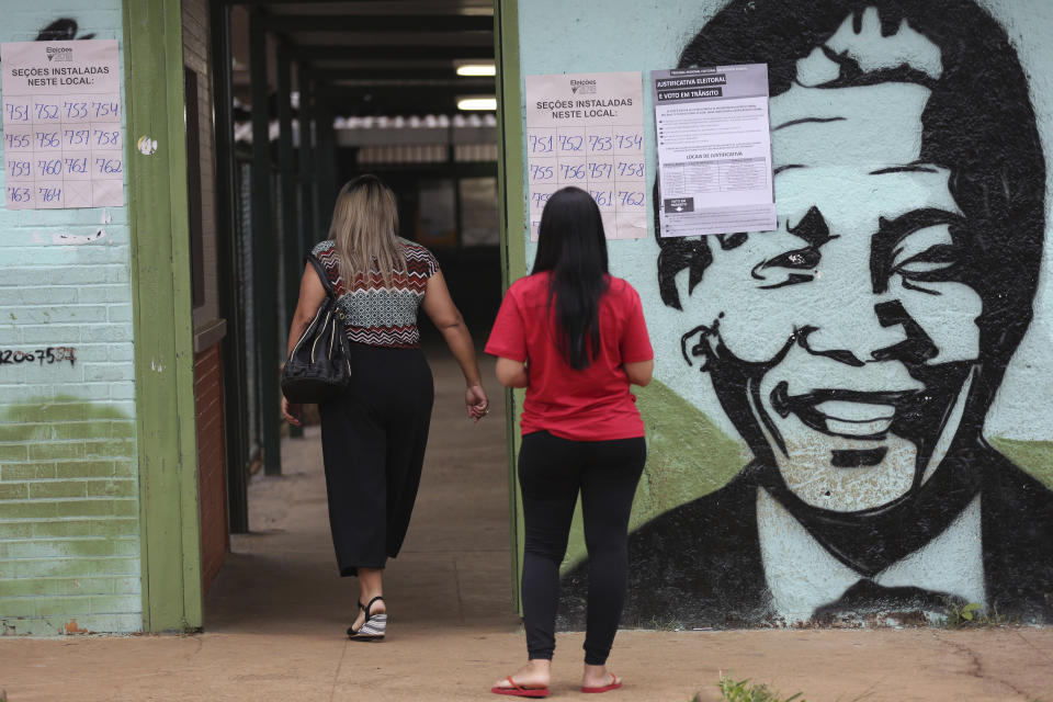 Voting information is displayed on a wall emblazoned with a mural of Nelson Mandela at a polling station in a suburb of Brasilia, Brazil, Sunday, Oct. 7, 2018. Brazilians choose among 13 candidates for president Sunday in one of the most unpredictable and divisive elections in decades. If no one gets a majority in the first round, the top two candidates will compete in a runoff. (AP Photo/Eraldo Peres)