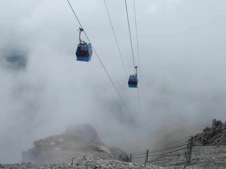 This Sept. 21, 2018 photo shows cable cars ascending nearly a kilometer to the top of the Jade Dragon Snow Mountain in the southern province of Yunnan in China home to the Baishui Glacier No.1. Scientists say the glacier is one of the fastest melting glaciers in the world due to climate change and its relative proximity to the Equator. It has lost 60 percent of its mass and shrunk 250 meters since 1982. (AP Photo/Sam McNeil)