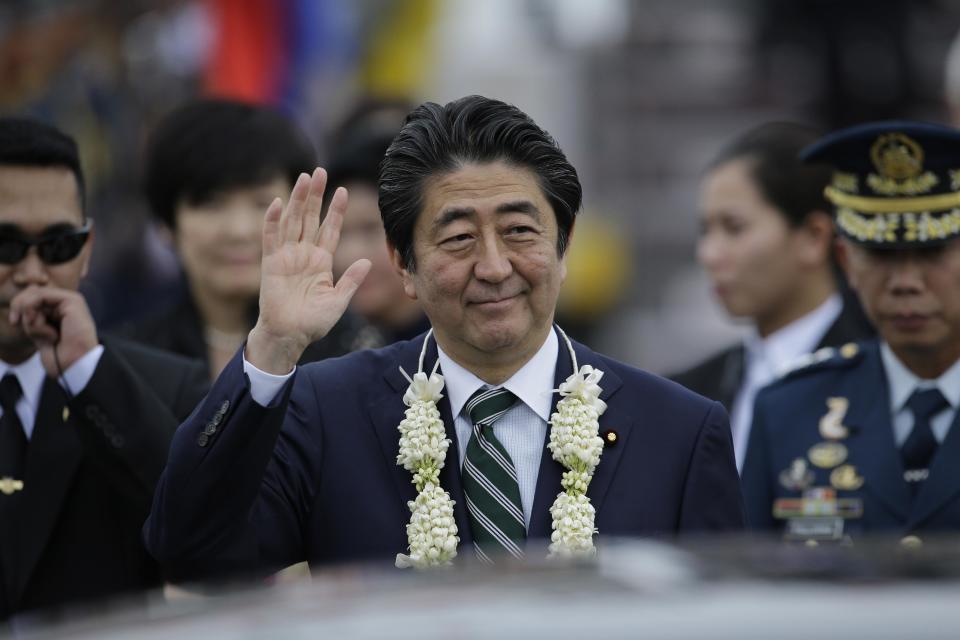 Japanese Prime Minister Shinzo Abe waves as he alights from his plane upon arrival at Manila airport, Philippines, Thursday, Jan. 12, 2017. Abe is in the country for a two-day official visit. (AP Photo/Aaron Favila)