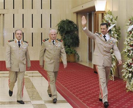 Syria's President Bashar al-Assad (R) waves as he arrives with Syrian Defense Minister General Ali Habib (C) and Chief of Staff General Dawoud Rajha to attend a dinner to honour army officers on the 65th Army Foundation anniversary in Damascus August 1, 2010. REUTERS/Sana/Files
