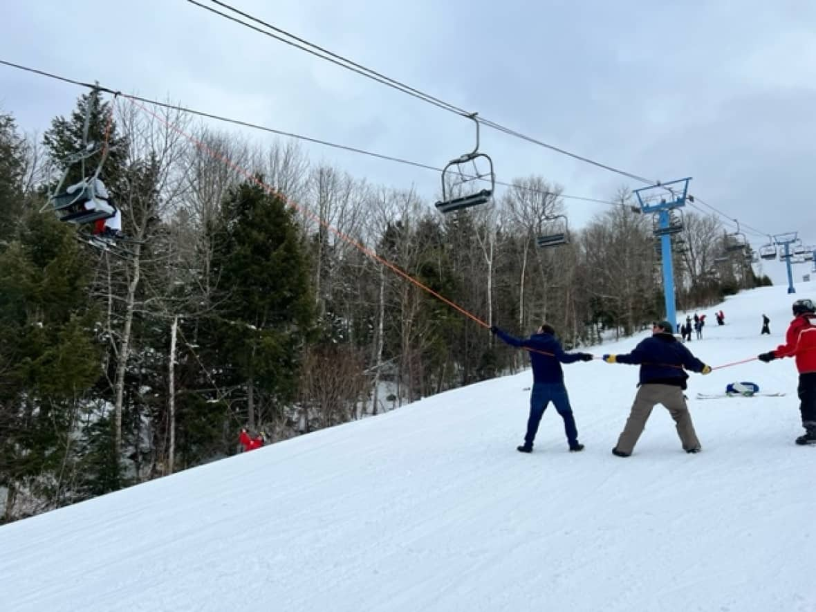 A team helps to evacuate skiiers from the alpine chairlift at Poley Mountain on Friday. (Submitted by Angie Titus - image credit)