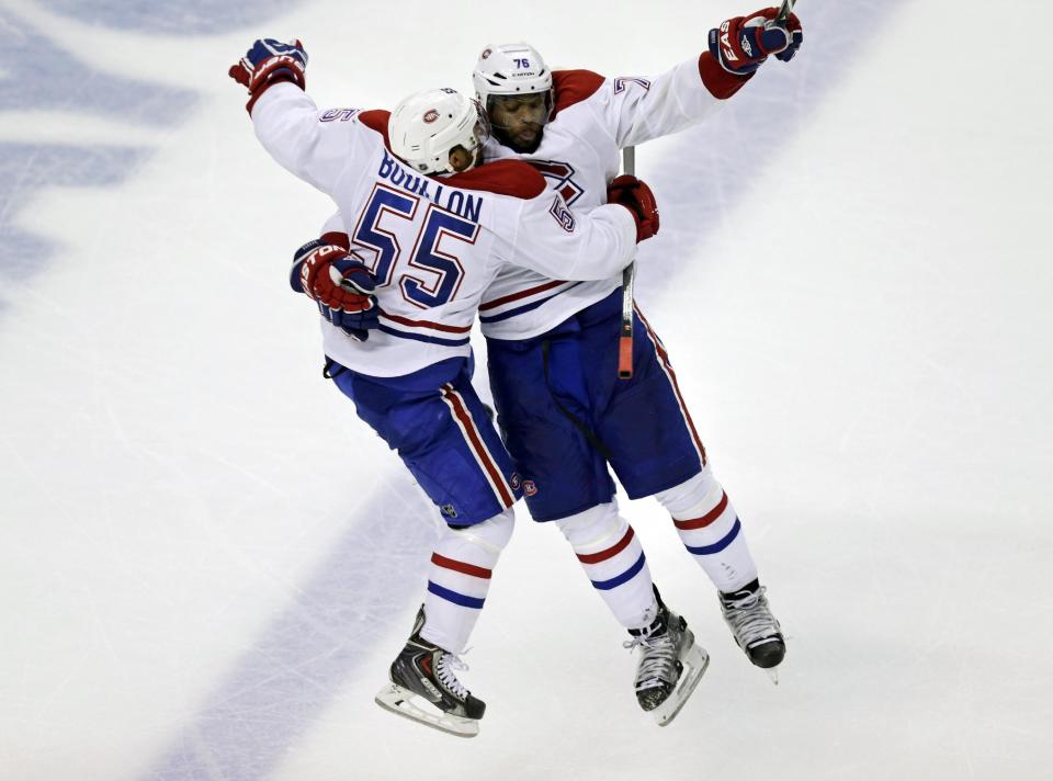 Montreal Canadiens defenseman Francis Bouillon (55) leaps into the arms of teammate P.K. Subban (76) after scoring on Boston Bruins goalie Tuukka Rask, breaking a 2-2 tie, during the third period of Game 1 in the second-round of the Stanley Cup playoff series in Boston, Thursday, May 1, 2014. (AP Photo/Charles Krupa)