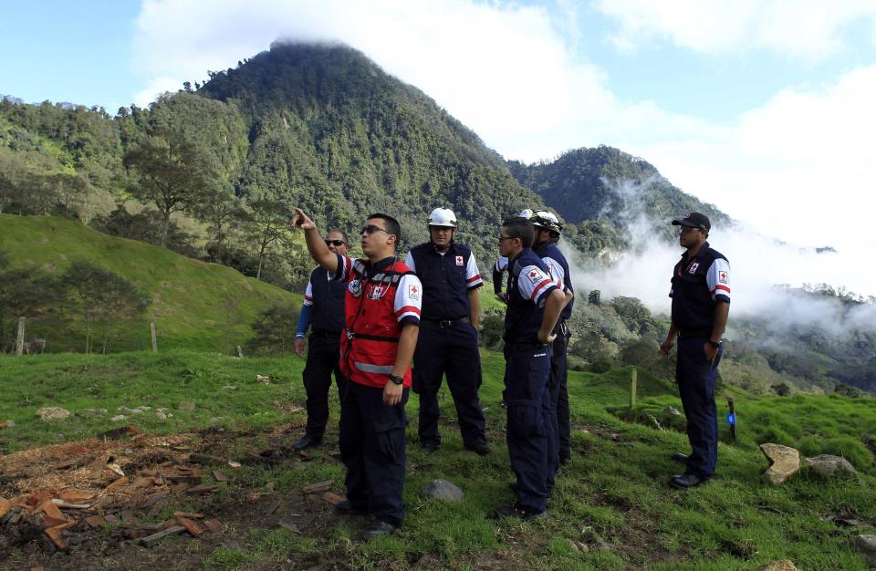 Red cross workers inspect a property on the slopes of the Turrialba volcano, in El Roble near Turrialba