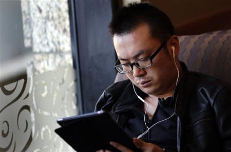 A man use his iPad inside a local coffee shop in downtown Shanghai November 28, 2013. REUTERS/Carlos Barria