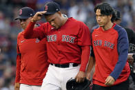 Boston Red Sox starting pitcher Eduardo Rodriguez, leaves with an injury, accompanied by manager Alex Cora, left, and team trainer Masai Takahashi iduring the second inning of the team's baseball game against the New York Yankees at Fenway Park, Friday, July 23, 2021, in Boston. (AP Photo/Elise Amendola)