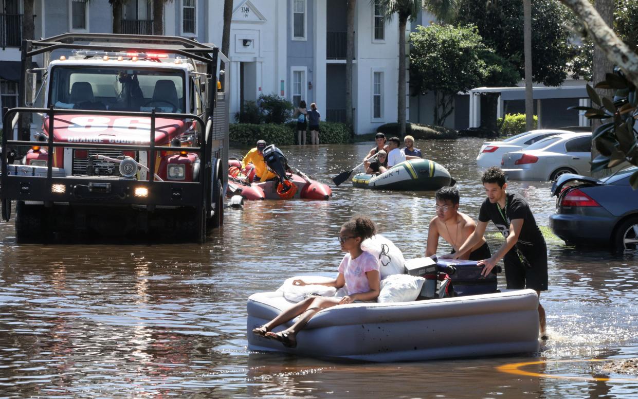 With Orange County Fire Rescue on the scene, residents of Arden Villas apartments use rubber boats, air mattresses and kiddie pools to float their belongings out of their homes, Friday, September 30, 2022, after heavy rains from Hurricane Ian flooded the complex near the University of Central Florida on Thursday. 