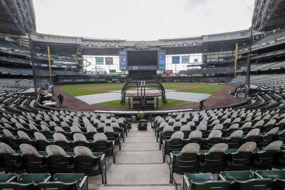 FILE - In this Friday, July 31, 2020, file photo, fan cutouts sit in seats behind home plate at Miller Park after it was announced that the baseball game between the Milwaukee Brewers and Cardinals in Milwaukee, was postponed after two Cardinals employees tested positive for the coronavirus. One more player and three staff members with the Cardinals have tested positive for the coronavirus, leading to the postponement of their game on Saturday against the Brewers, according to a person familiar with the situation. (AP Photo/Morry Gash, File)