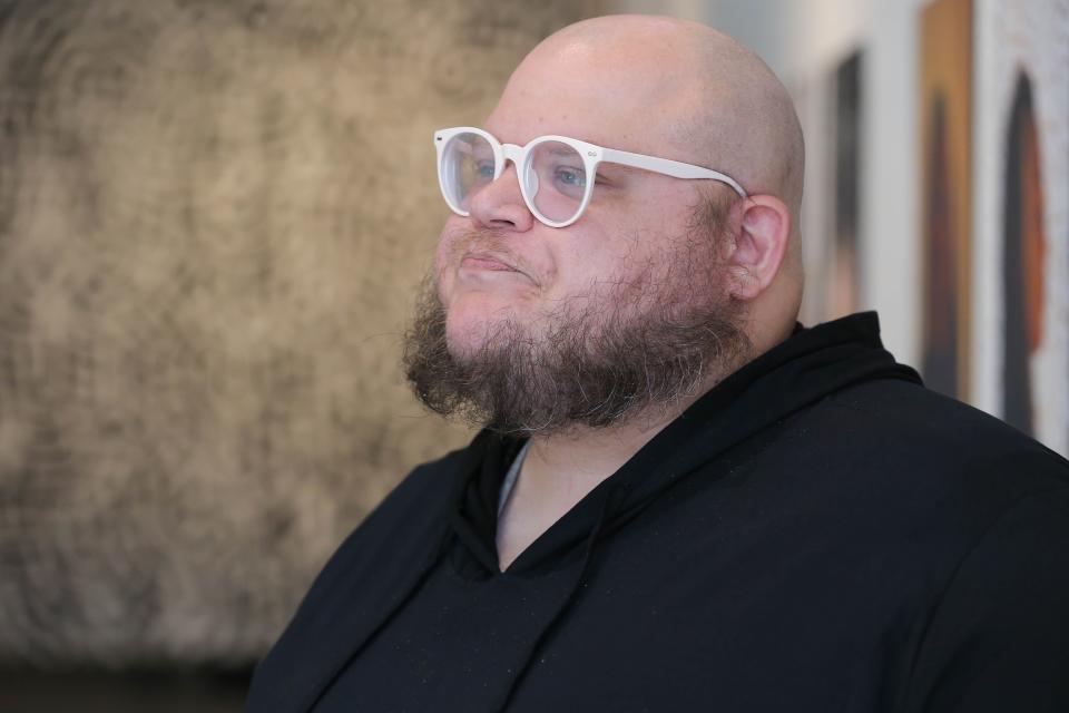 Cody Giles stands near his art at the Mainsite Contemporary Art Gallery in Norman on Friday, Aug. 12, 2022.