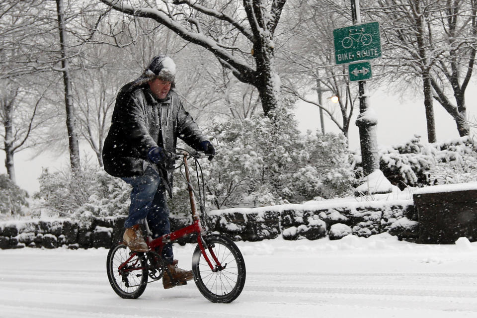 A cyclist makes his way up the Hudson River Greenway as heavy snow falls Monday, Feb. 3, 2014, in New York. (AP Photo/Jason DeCrow)