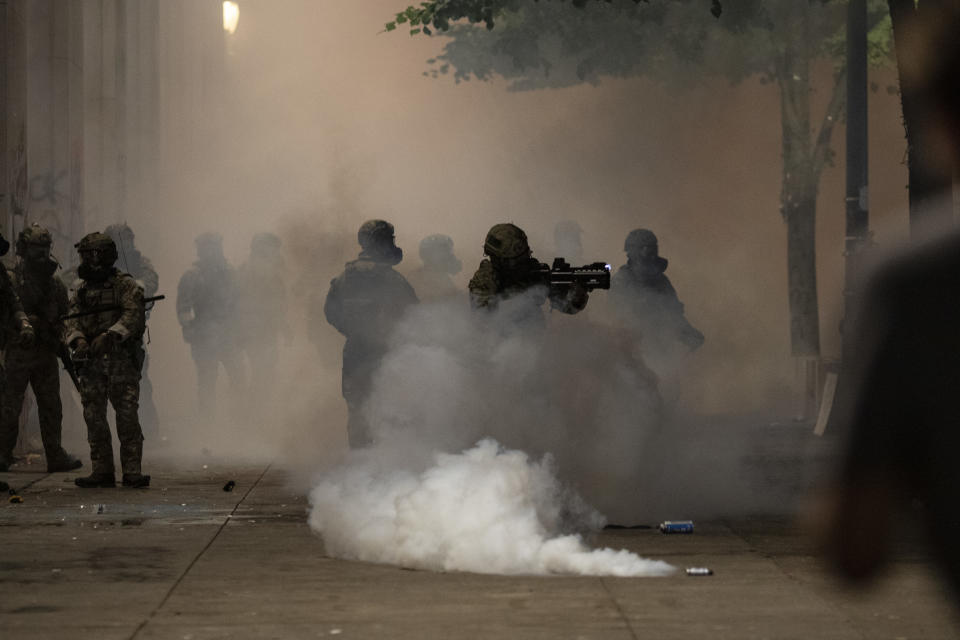 PORTLAND, OR - JULY 22: Federal officers are surrounded by tear gas while clearing the street in front of the Mark O. Hatfield U.S. Courthouse on July 22, 2020 in Portland, Ore. The federal police response to the ongoing protests against racial inequality has been criticized by city and state elected officials.  (Photo by Paula Bronstein/Washington Post
