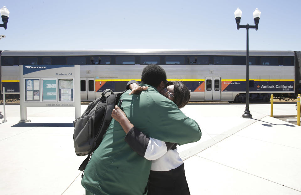 In this photo taken Wednesday, July 17, 2013, Ida Johnson greets her son, Ronnie Greene, at the Amtrak stop in Madera, Calif. Johnson, moved to the Central Valley after she retired from a job in the San Francisco Bay Area, and takes the train to visit friends who still live there, looks forward to the construction of a high-speed rail system.The state's plan to build the first high-speed rail system in the nation is intended to alleviate gridlock, connect the Central Valley to better jobs, and ease pollution, but many residents oppose the $68 billion project.(AP Photo/Rich Pedroncelli)