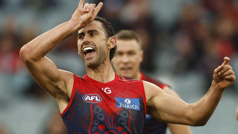 Brodie Grundy throws up a devil's horn celebration after kicking a goal for the Demons.