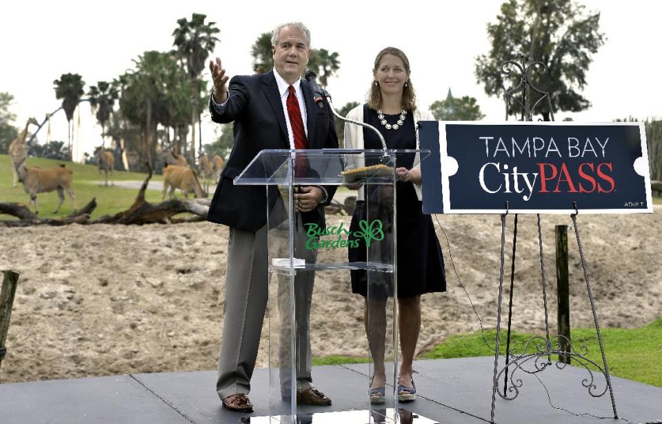 Mike Gallagher, left, co-founder and co-chairman of CityPass, gestures during a news conference Wednesday, Feb. 26, 2014, at Busch Gardens Tampa Bay in Tampa, Fla., after it was announced that CityPass would be coming to the area. Several Tampa Bay-area attractions, including the Busch Gardens theme park, will be part of a ticket pass booklet that's offered in other cities such as New York, Chicago and Toronto. The $119 CityPass booklet allows tourists to see up to five attractions over nine consecutive days, including Busch Gardens, The Florida Aquarium, Clearwater Marine Aquarium, Lowry Park Zoo and either the Chihuly glass museum or the Museum of Science and Industry. It's the only location in Florida that offers such a pass. Looking on is Megan Allen, CEO of CityPass. (AP Photo/Chris O'Meara)