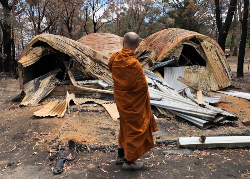 The Abbot of Sunnataram Forest Monastery, Phra Mana, 56, looks at the ruins of a burnt female dormitory in Bundanoon, Australia