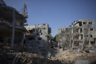 Palestinians inspect their destroyed houses following overnight Israeli airstrikes in town of Beit Hanoun, northern Gaza Strip, Friday, May 14, 2021. (AP Photo/Khalil Hamra)