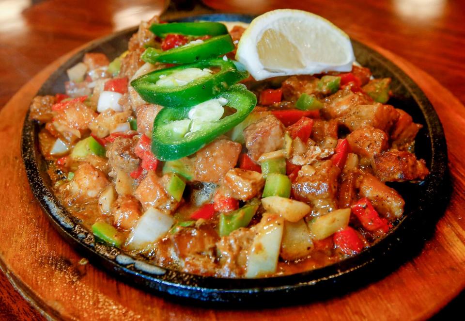 A plate of pork chunks and cubed peppers, topped with jalapeno slices.