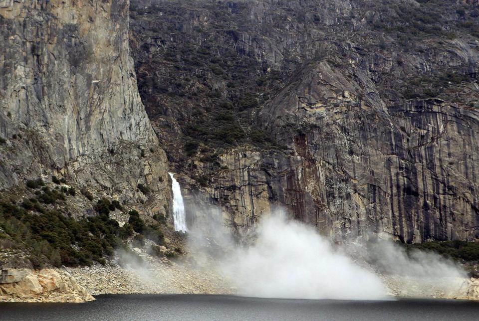 In this photo supplied by Yosemite National Park, dust rises from a rockfall on Monday, March 31, 2014. Officials at Yosemite National Park say a massive amount of rock has fallen from a cliff, closing a hiking trail. The National Park Service said nobody was hurt on March 31 when approximately 16,000 tons of rock fell 500 feet from a cliff near Hetch Hetchy Reservoir. Officials say the rock crashed down from a cliff east of Wapama Falls. Some 400 feet of the Rancheria Falls Trail were destroyed and park staff says it will remain closed for now. Park officials say hikers can still get to Wampama Falls starting at O'Shaughnessy Dam. (AP Photo/Yosemite National Park)