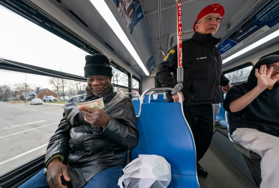 Michael James, 73, of Detroit, smiles after being gifted $100 by a Secret Santa elf in Lincoln Park Monday, Dec. 5, 2022. "I am going to buy a good pair of shoes," James said.