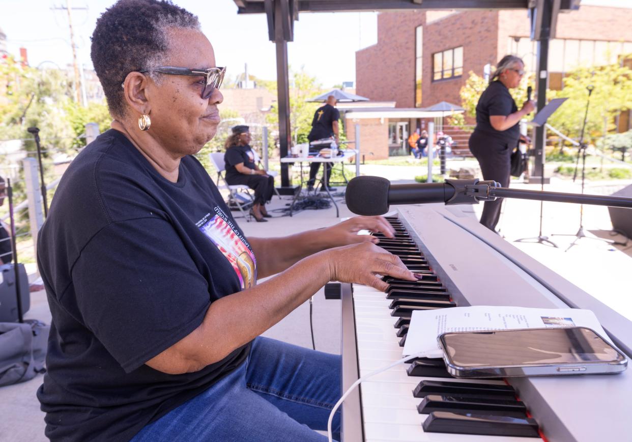 Gayle Danzy plays the keyboard as minister Dorothy Young prays for America's families at the National Day of Prayer held at Duncan Plaza in Massillon.