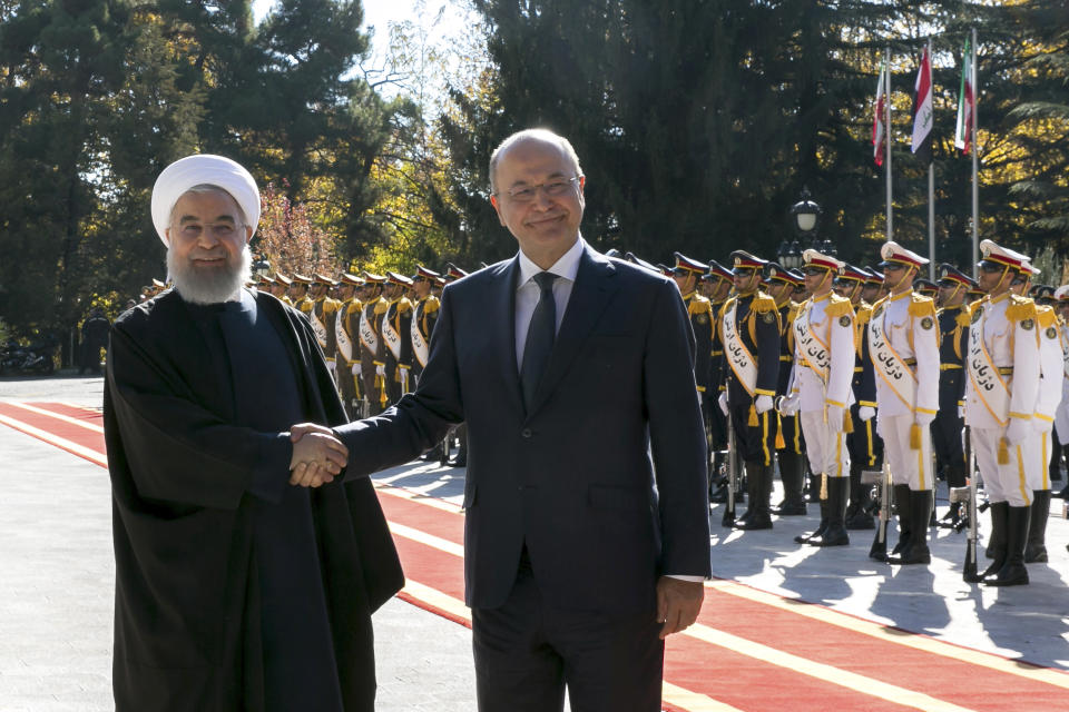 In this photo released by official website of the Office of the Iranian Presidency, Iraqi President Barham Salih, right, and his Iranian counterpart Hassan Rouhani shake hands during an official welcome ceremony for Salih at the Saadabad Palace in Tehran, Iran, Saturday, Nov. 17, 2018. Salih is visiting Iran less than two weeks after the United States restored oil sanctions that had been lifted under the 2015 nuclear deal. (Iranian Presidency Office via AP)