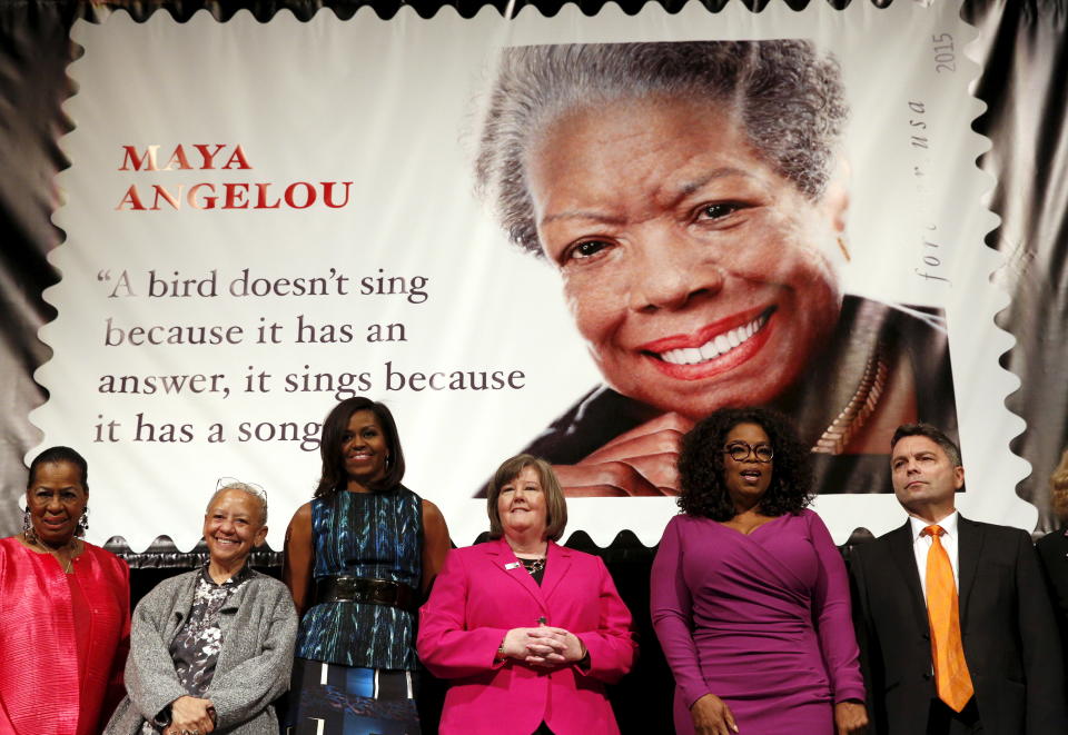 People stand on stage during the Maya Angelou Forever stamp dedication ceremony in Washington April 7,  2015. Onstage (L-R) are Howard University Professor Eleanor Traylor, writer Nikki Giovanni, first lady Michelle Obama, Postmaster General Megan Brennan, Oprah Winfrey and artist Ross Rossin. REUTERS/Kevin Lamarque 