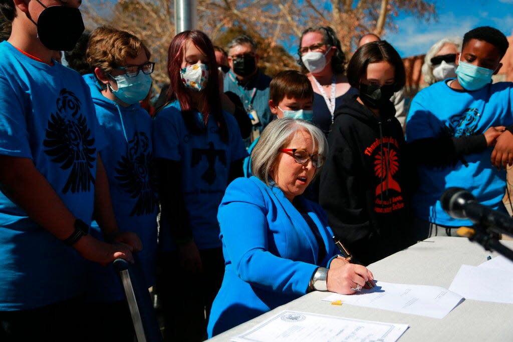 Gov. Michelle Lujan Grisham signs one of a suite of education bills that will increase teacher salaries and benefits on Tuesday, March 1, 2022, in Santa Fe, N.M. Lujan Grisham signed the bills near the playground of the Francis X. Nava Elementary School alongside grade school students, legislative leaders, and teacher union representatives.
