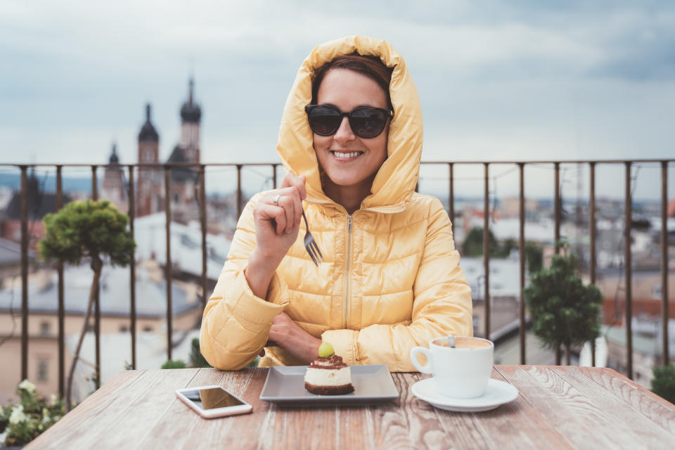 Tourist woman on the rooftop enjoying sweet dessert