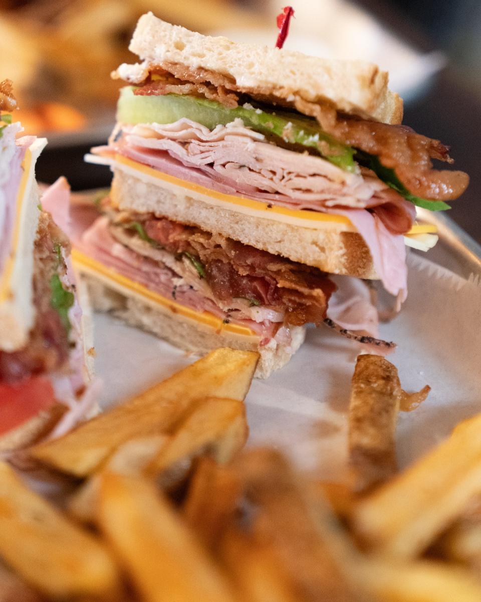 The club sandwich from Beyond Q features two layers of turkey, ham, cheese, lettuce and bacon served with fries, honey mustard and ranch dressing.