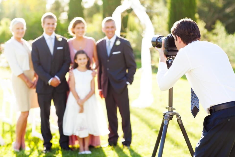 A photographer taking a group photo at a wedding