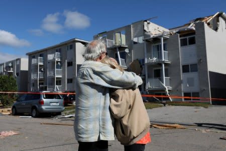 Residents embrace while looking at the damage after a tornado hit the Mont-Bleu neighbourhood in Gatineau, Quebec, Canada, September 22, 2018. REUTERS/Chris Wattie