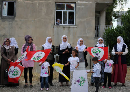 People wave flags as they attend a campaign event of Turkey's main pro-Kurdish Peoples' Democratic Party (HDP) in Silvan, a town in Diyarbakir province, Turkey, June 5, 2018. Picture taken June 5, 2018. REUTERS/Umit Bektas