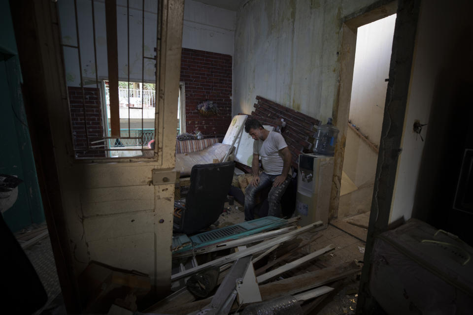 Found Armali sits inside his destroyed apartment after Tuesday's explosion in the seaport of Beirut, Lebanon, Thursday, Aug. 6, 2020. The gigantic explosion in Beirut on Tuesday tore through homes, blowing off doors and windows, toppling cupboards, and sent flying books, shelves, lamps and everything else. Within a few tragic seconds, more than a quarter of a million people of the Lebanese capital's residents were left with homes unfit to live in. Around 6,200 buildings are estimated to be damaged. (AP Photo/Hassan Ammar)