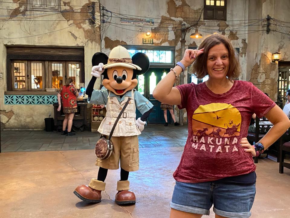 kari posing for a distances photo with mickey mouse in safari gear at tusker house