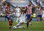 Atletico Madrid's Miranda, Real Madrid's Fabio Coentrao and Atletico Madrid's Juanfran (L-R) fight for the ball during their Champions League final soccer match at the Luz stadium in Lisbon May 24, 2014. REUTERS/Paul Hanna (PORTUGAL)