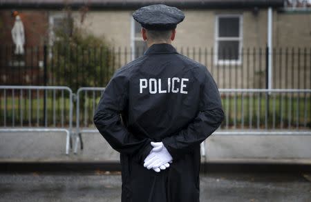 A Police officer stands in the rain near the Greater Allen A.M.E. Cathedral of New York ahead of the funeral service for slain New York City Police (NYPD) officer Randolph Holder in the Queens borough of New York City, October 28, 2015. REUTERS/Shannon Stapleton