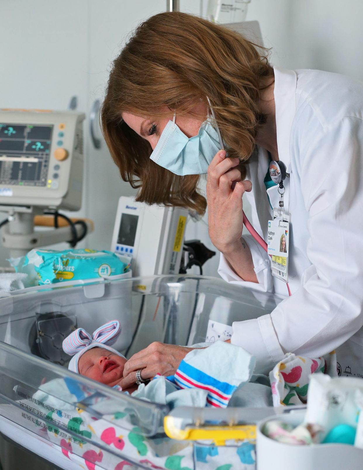Dr. Katie Clark checks newborn Charlotte Long on the Mother Baby Unit at Cleveland Clinic Akron General. Clark,  a mother of four, is finishing her residency at the hospital and will start this summer as a family medicine doctor in Stow.