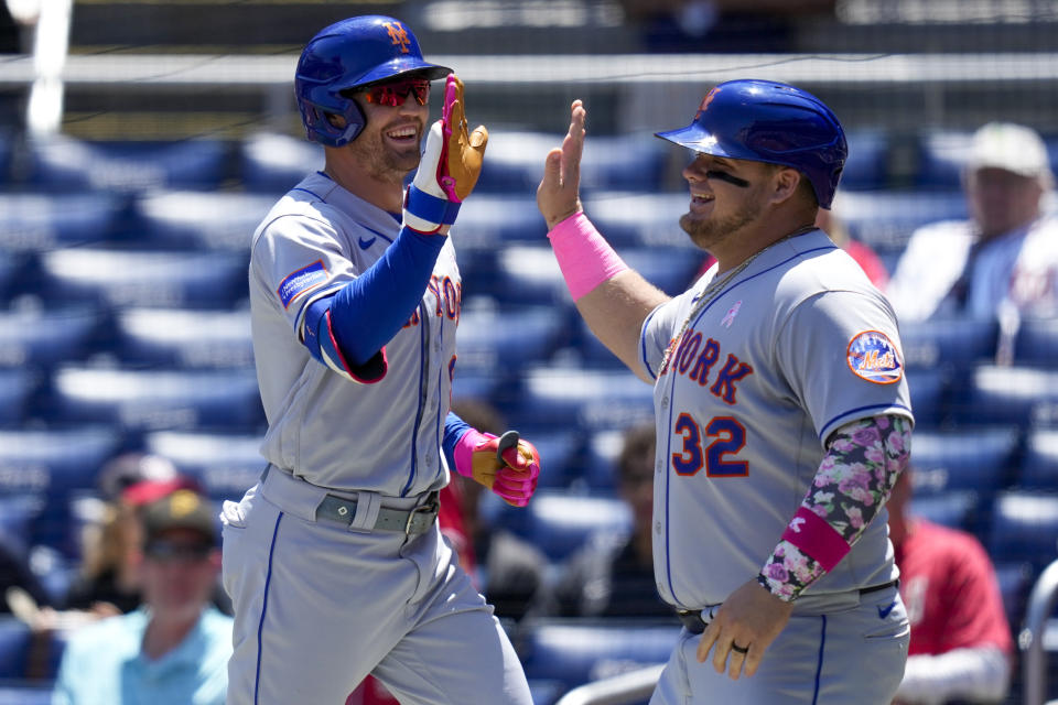 New York Mets' Brandon Nimmo, left, and Daniel Vogelbach celebrate after Vogelbach scored on a sacrifice fly by Nimmo during the third inning of the continuation of a suspended baseball game against the Washington Nationals at Nationals Park, Sunday, May 14, 2023, in Washington. (AP Photo/Alex Brandon)
