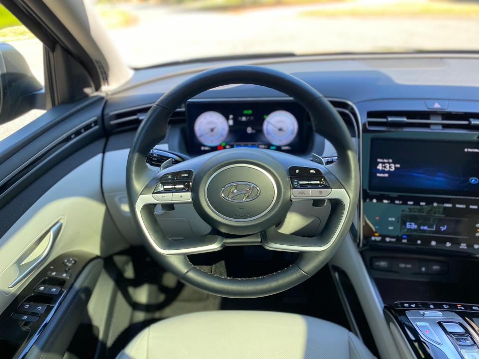 From the driver's seat, the steering wheel of a 2024 Hyundai Tucson Hybrid SUV.