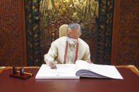 In this photo provided by the Malacanang Presidential Photographers Division, Chinese Foreign Minister Wang Yi signs the guest book as he arrives for a courtesy call on Philippine President Ferdinand Marcos Jr. at the Malacanang Presidential Palace in Manila, Philippines on Wednesday, July 6, 2022. (Malacanang Presidential Photographers Division via AP)