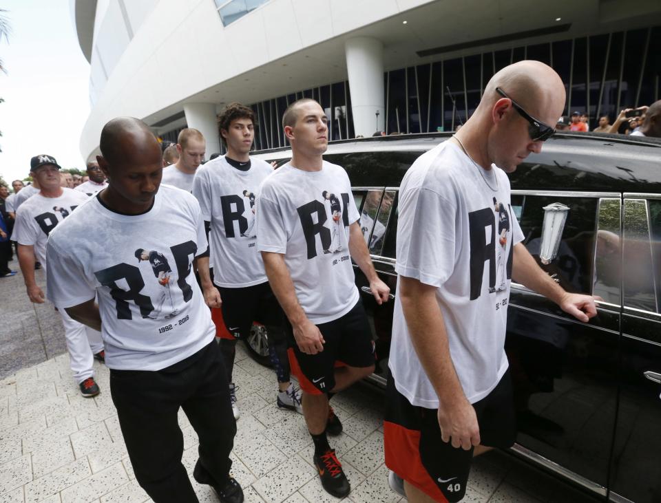 <p>Somber Miami Marlins players, including Mike Donn (40), J.T. Realmuto (11) and Christian Yelich (21), walk alongside a hearse carrying the body of pitcher Jose Fernandez as it leaves Marlins Park stadium, Wednesday, Sept. 28, 2016, in Miami. Fernandez was killed in a weekend boat crash along with two friends. (AP Photo/Wilfredo Lee) </p>