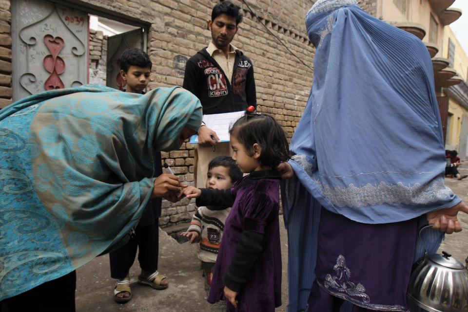 In this Feb. 2, 2014 photo, a Pakistani health worker marks the finger of a child after giving her a polio vaccine, in Peshawar, Pakistan. Pakistan’s beleaguered battle to eradicate polio is threatening a global, multi-billion dollar campaign to wipe out the disease worldwide. Because of Pakistan, the virus is spreading to countries that were previously polio free, say U.N. officials. “The largest poliovirus reservoir of the world,” is in Peshawar, the capital of Pakistan’s northwest Khyber Pukhtunkhwa province, which borders Afghanistan, according to the World Health Organization. (AP Photo/Mohammad Sajjad)