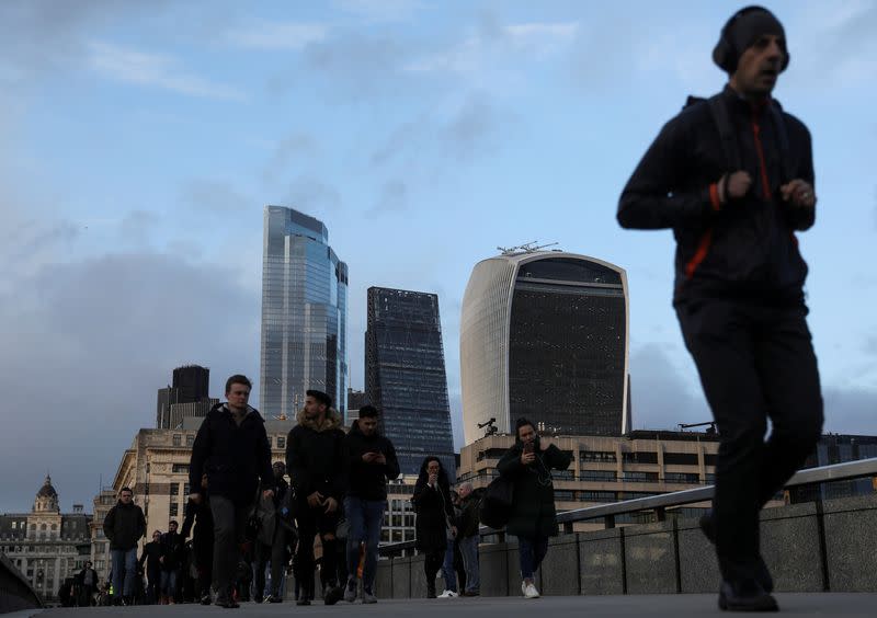 FILE PHOTO: Pedestrians walk along London Bridge in view of skyscrapers in the financial district in Londo