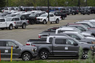 Ford pickup trucks built lacking computer chips are shown in parking lot storage in Dearborn, Mich., Tuesday, May 4, 2021. Automakers are cutting production as they grapple with a global shortage of computer chips, and that's making dealers nervous. (AP Photo/Paul Sancya)