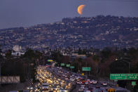 <p>A super blue blood moon is seen setting behind the Hollywood hills in Los Angeles on Wednesday Jan. 31, 2018. (Photo: Richard Vogel/AP) </p>